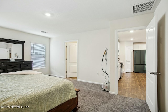 bedroom featuring black fridge and carpet