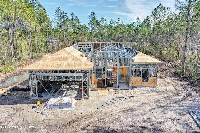 view of front of home featuring an outdoor structure and a forest view