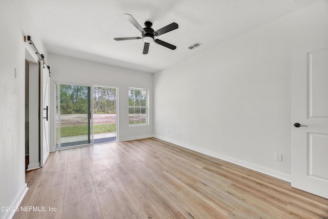 unfurnished room with visible vents, light wood-style flooring, ceiling fan, and baseboards