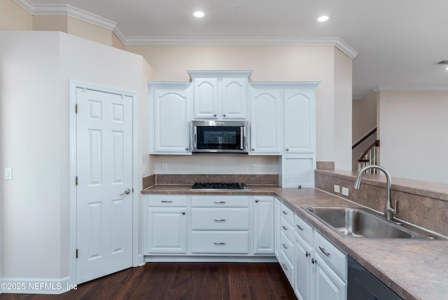 kitchen featuring dark hardwood / wood-style floors, white cabinetry, sink, ornamental molding, and stainless steel appliances