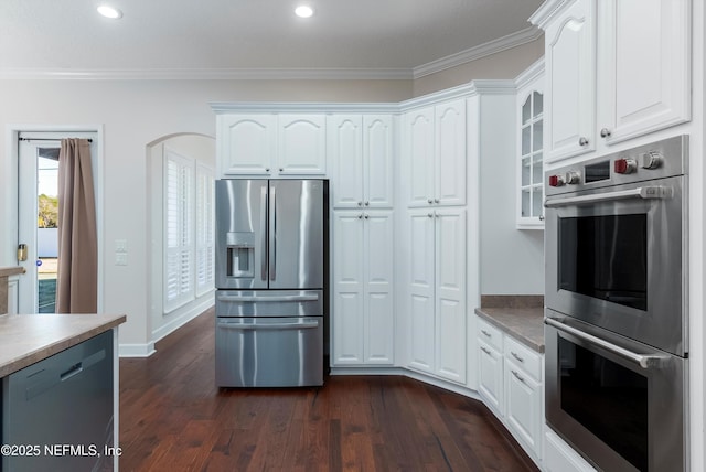 kitchen with ornamental molding, stainless steel appliances, dark hardwood / wood-style floors, and white cabinets