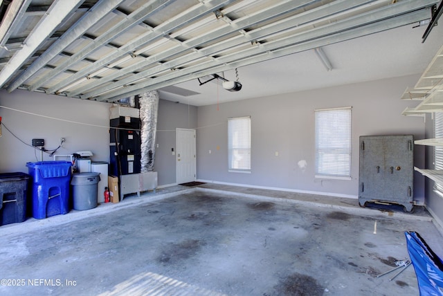 garage featuring heating unit and a garage door opener