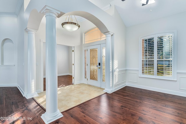 entrance foyer with dark hardwood / wood-style flooring, ornamental molding, and decorative columns