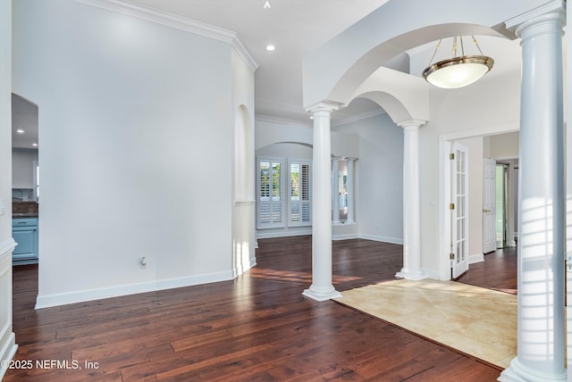 entrance foyer featuring dark hardwood / wood-style flooring, crown molding, and decorative columns