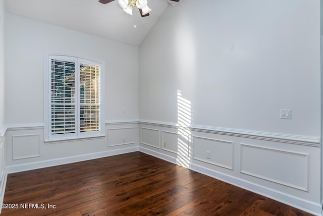 spare room with dark hardwood / wood-style flooring, vaulted ceiling, and ceiling fan