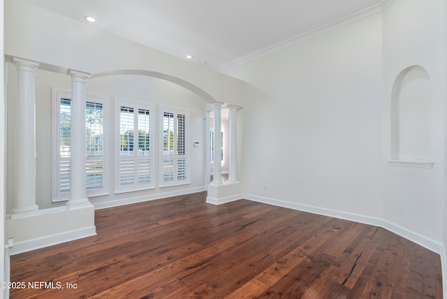 unfurnished room featuring ornamental molding, dark wood-type flooring, and decorative columns