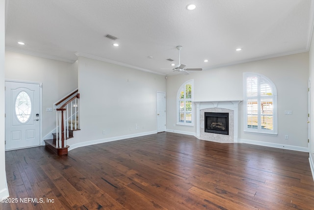 unfurnished living room featuring crown molding, ceiling fan, a fireplace, and dark hardwood / wood-style flooring