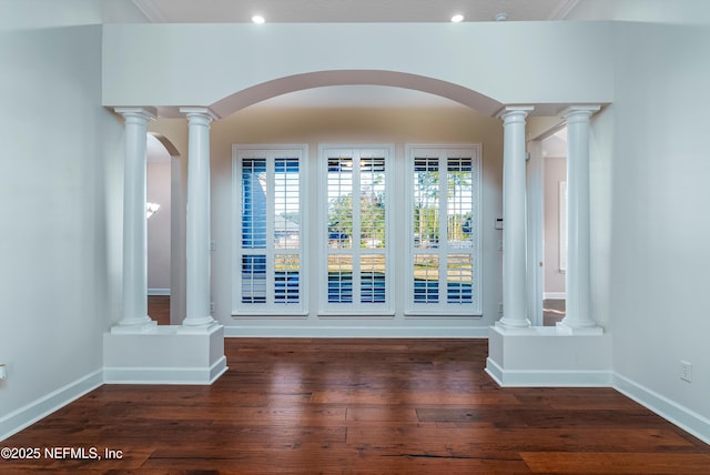 unfurnished room with dark wood-type flooring and ornate columns