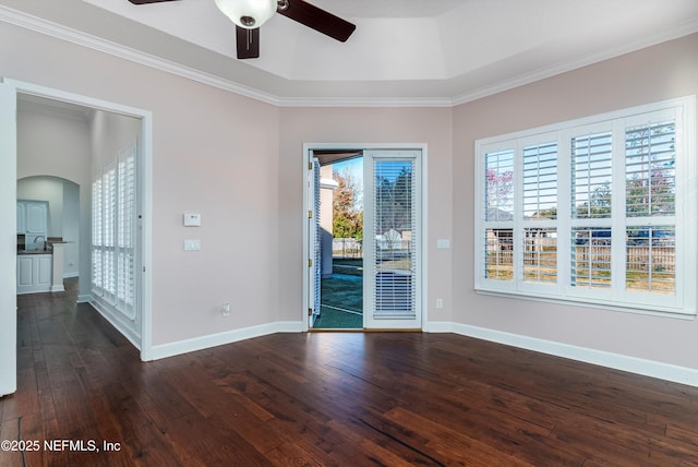 spare room with a healthy amount of sunlight, dark hardwood / wood-style floors, crown molding, and ceiling fan