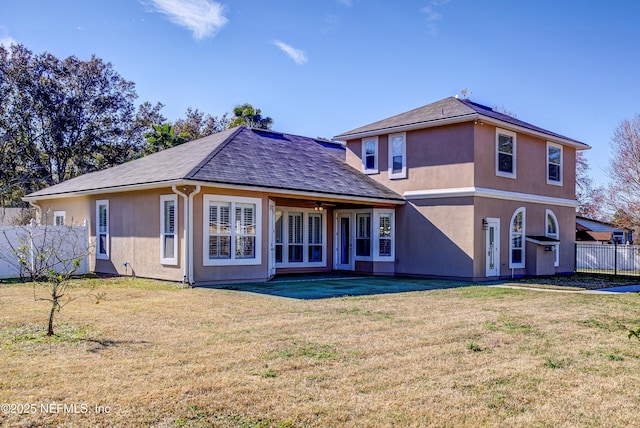 rear view of property featuring a lawn