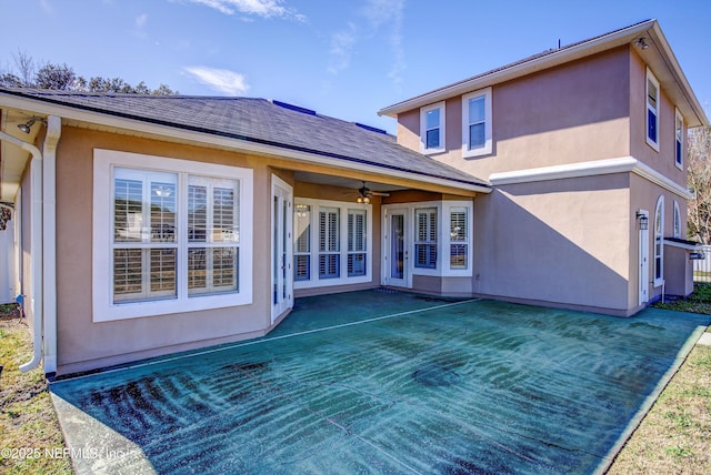 rear view of property featuring ceiling fan and a lawn