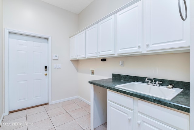 washroom with sink, hookup for a washing machine, cabinets, and light tile patterned floors