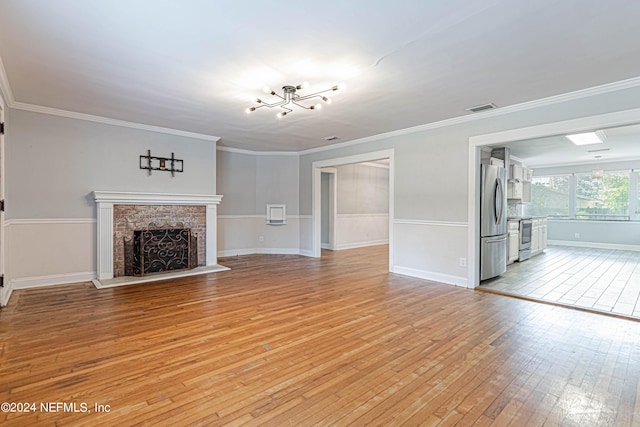 unfurnished living room with light hardwood / wood-style flooring, crown molding, and a fireplace