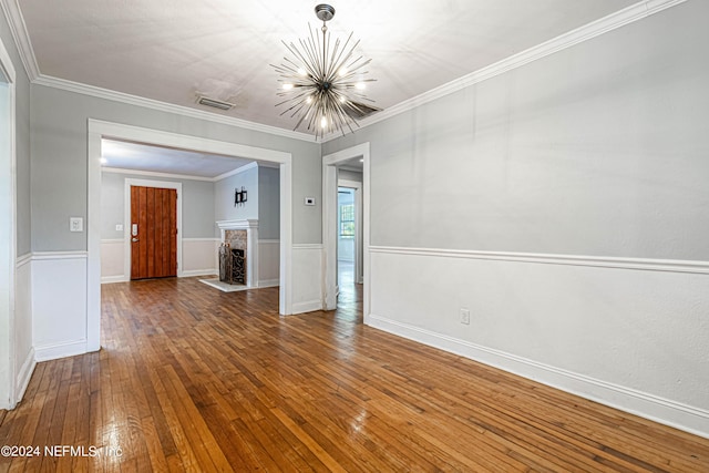 interior space with an inviting chandelier, crown molding, and hardwood / wood-style flooring