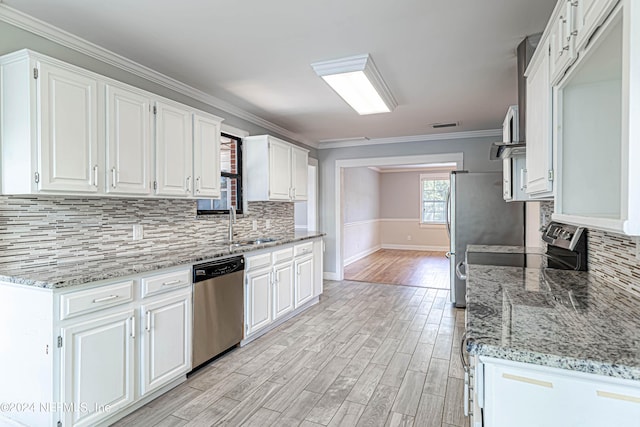 kitchen featuring crown molding, stainless steel appliances, light hardwood / wood-style flooring, and white cabinets