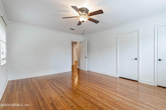 unfurnished bedroom with crown molding, two closets, ceiling fan, and light hardwood / wood-style floors