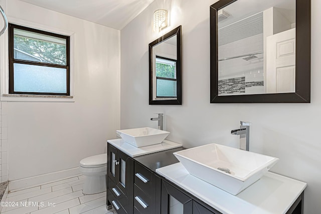 bathroom featuring vanity, toilet, and walk in shower