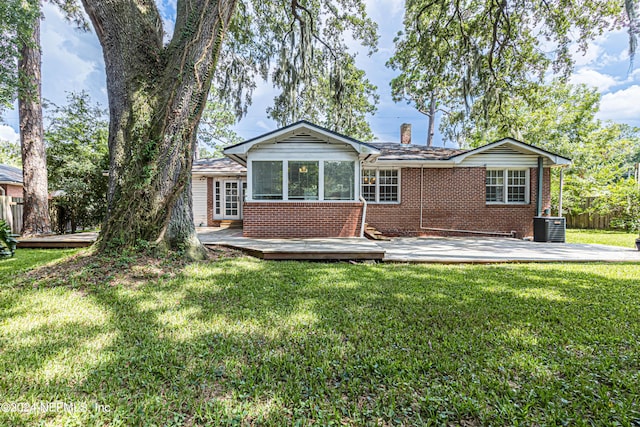 back of house featuring central AC and a lawn