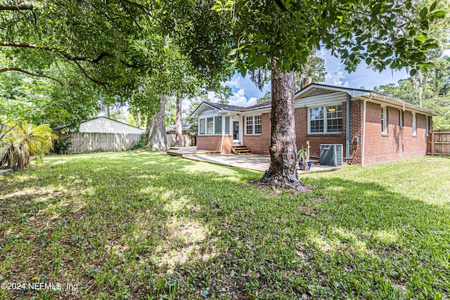 view of yard with central AC unit and a patio