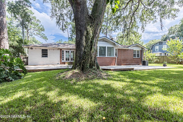 back of house featuring a wooden deck, central AC unit, and a lawn