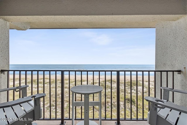 balcony featuring a water view and a beach view