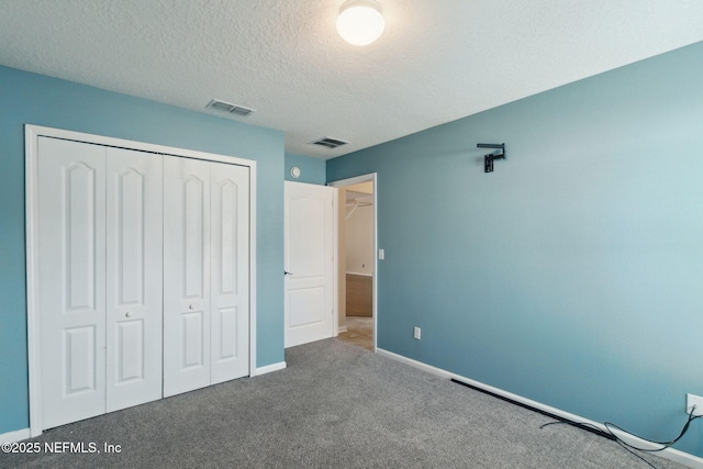 unfurnished bedroom featuring carpet floors, a textured ceiling, and a closet