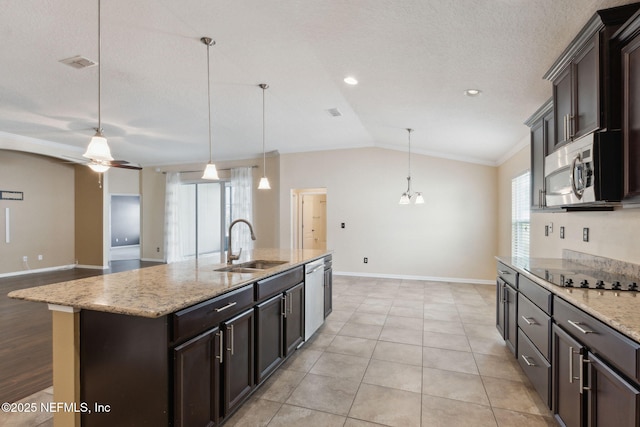 kitchen featuring sink, decorative light fixtures, stainless steel appliances, and a center island with sink