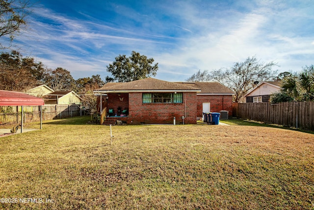 rear view of house with a carport, central AC unit, and a lawn