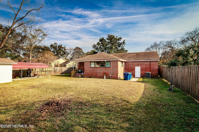 rear view of property featuring cooling unit, a carport, and a lawn