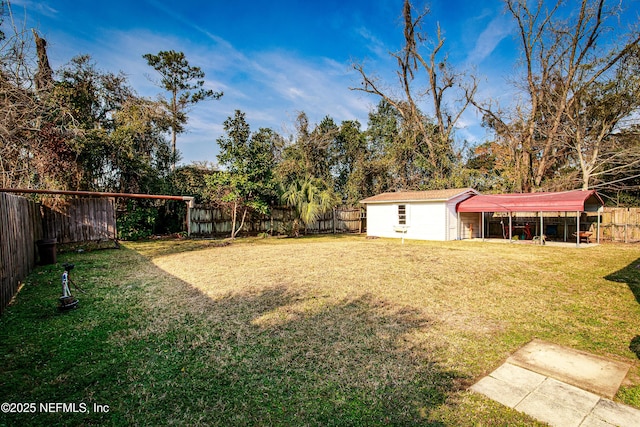 view of yard featuring a carport and a storage unit