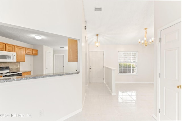 kitchen featuring pendant lighting, backsplash, white appliances, and a textured ceiling