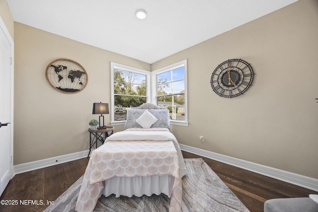 bedroom with dark hardwood / wood-style flooring