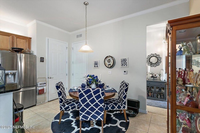 dining space featuring crown molding and light tile patterned flooring