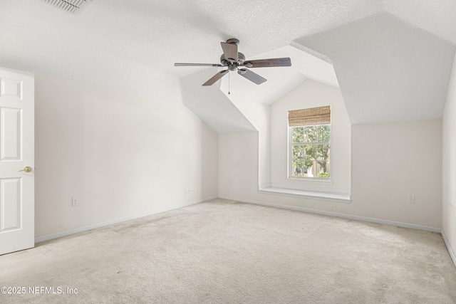 bonus room featuring ceiling fan, lofted ceiling, light carpet, and a textured ceiling