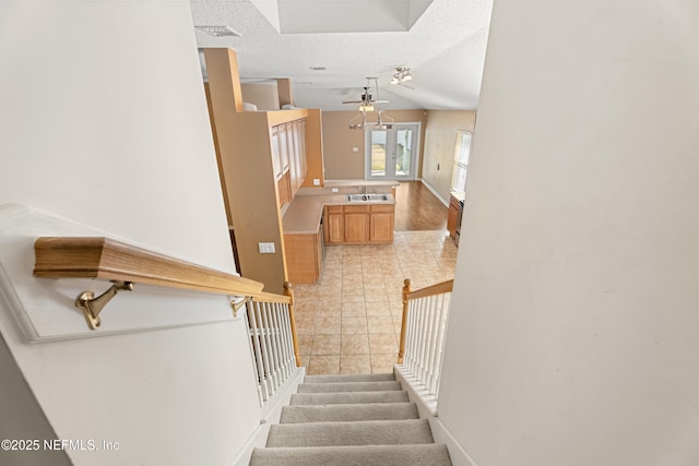 stairway featuring tile patterned floors, lofted ceiling, sink, a textured ceiling, and ceiling fan