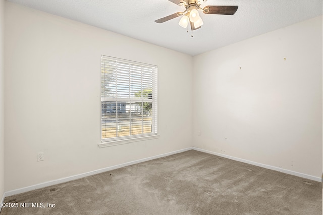 carpeted empty room with ceiling fan and a textured ceiling