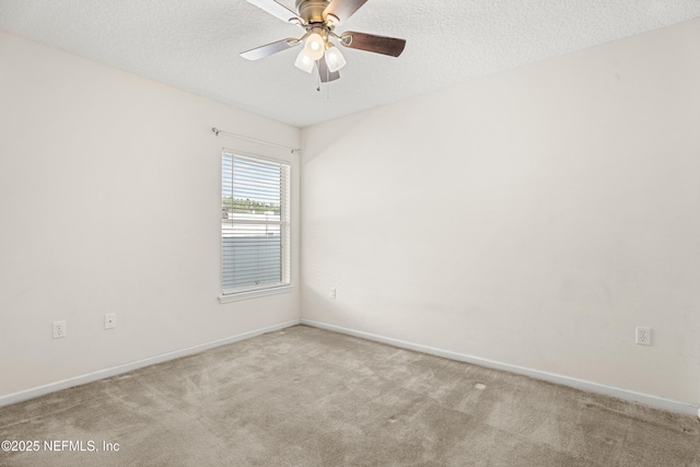 spare room featuring ceiling fan, light colored carpet, and a textured ceiling