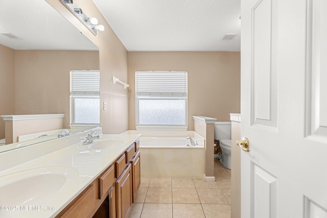 bathroom with a tub to relax in, tile patterned flooring, vanity, toilet, and a textured ceiling