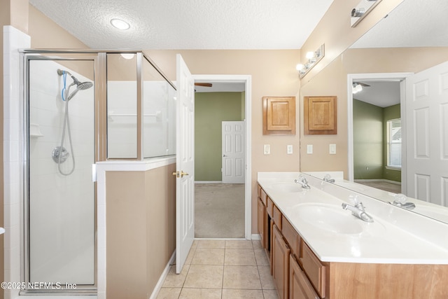 bathroom featuring an enclosed shower, vanity, tile patterned floors, and a textured ceiling