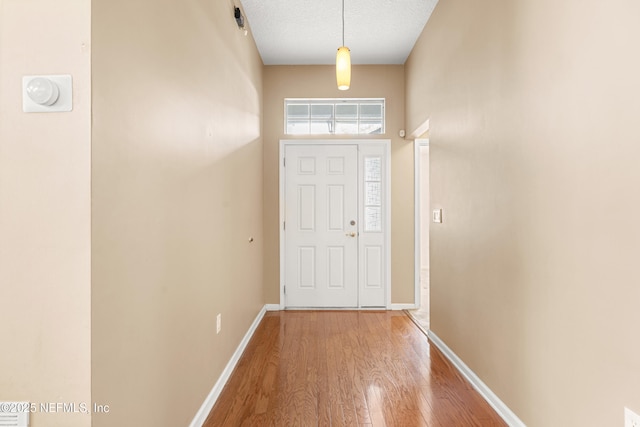 doorway with wood-type flooring and a textured ceiling