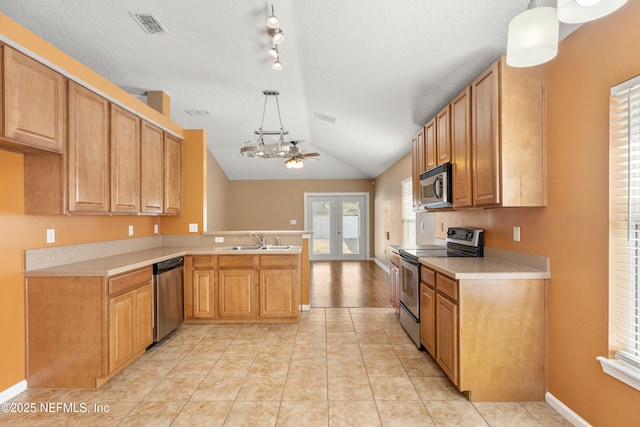 kitchen with appliances with stainless steel finishes, decorative light fixtures, sink, light tile patterned floors, and french doors