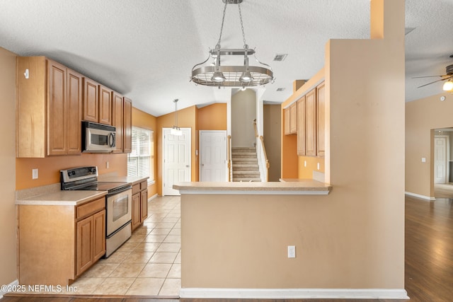 kitchen with ceiling fan, appliances with stainless steel finishes, decorative light fixtures, vaulted ceiling, and kitchen peninsula