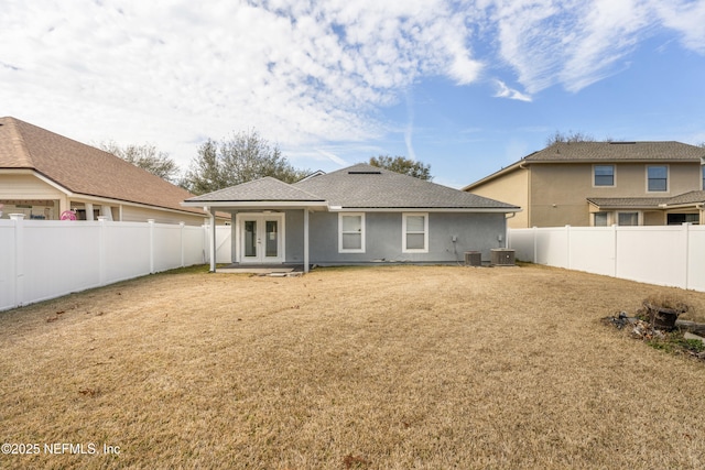 back of property with a lawn and central air condition unit