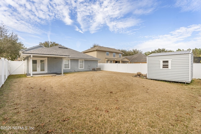 rear view of house featuring a storage shed, central AC, a lawn, and french doors