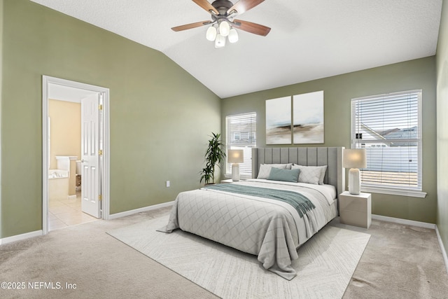 carpeted bedroom featuring ceiling fan, lofted ceiling, and ensuite bath