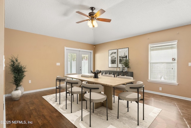 dining space with hardwood / wood-style floors, a textured ceiling, french doors, and a healthy amount of sunlight