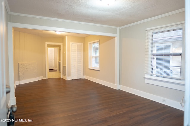 unfurnished room featuring ornamental molding, a healthy amount of sunlight, and dark hardwood / wood-style flooring