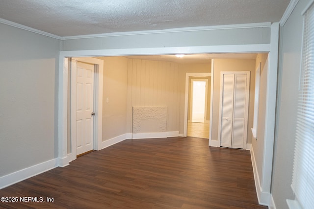 empty room featuring dark hardwood / wood-style flooring, ornamental molding, and a textured ceiling