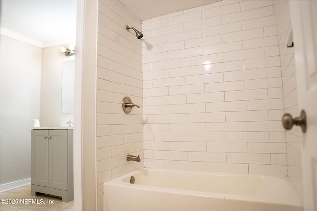 bathroom featuring tiled shower / bath and vanity