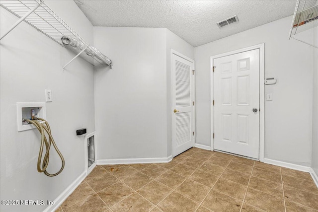 washroom featuring washer hookup, tile patterned floors, and a textured ceiling